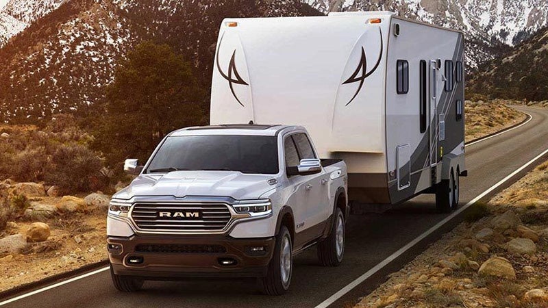 2019 Ram 1500 towing a camper trailer on a mountain highway